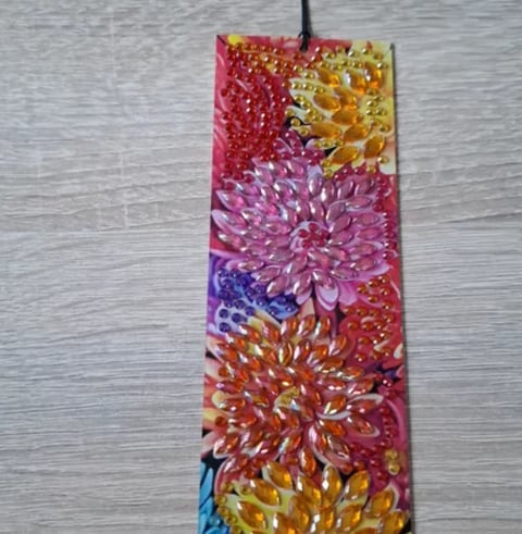 Vertical rectangular artwork featuring vibrant painted chrysanthemum flowers in red, pink, purple, yellow, orange, and blue with textured petals on wooden background