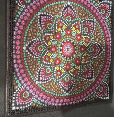 Colorful mandala dot painting on canvas with beaded gem embellishments in pink, red, yellow, white, and teal tones arranged in concentric circular patterns