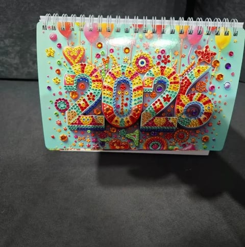 Colorful 2025 desk calendar with festive beaded and rhinestone decorations on mint green cover