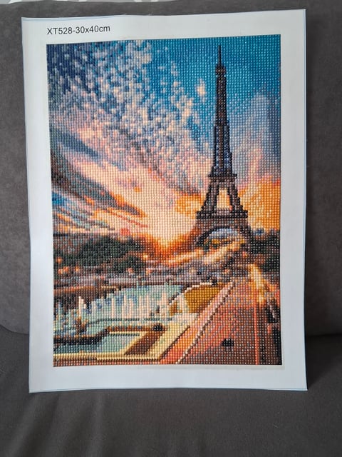 Pixelated cross-stitch artwork of Eiffel Tower at sunset over Paris with colorful sky and river reflection, 30x40cm