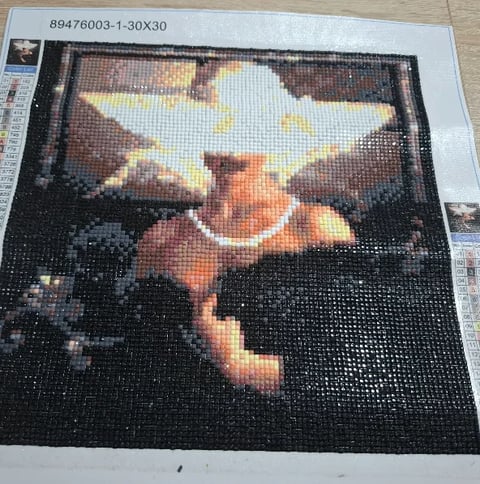 Pixel art mosaic depicting a blonde child with yellow star-shaped headpiece against dark background with warm tones