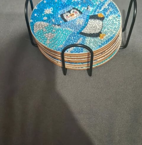 Round coaster with blue mosaic pattern featuring moon and stars, metal handles on sides, stacked on gray surface